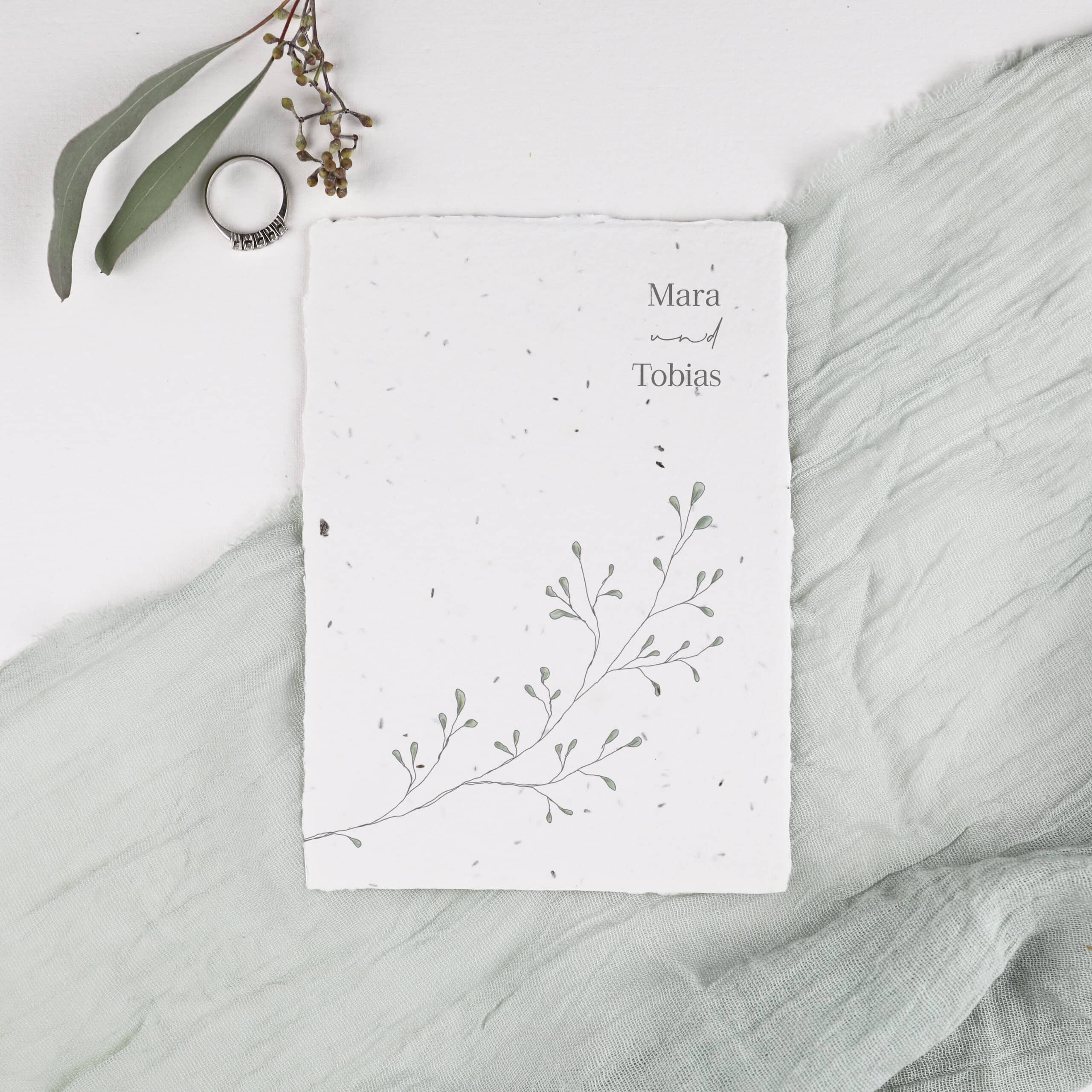 Einladungskarte zum Einpflanzen aus der Serie "Linnea" mit zarten Eukalyptuszweigen und einem Foto, das per Klammer befestigt wird