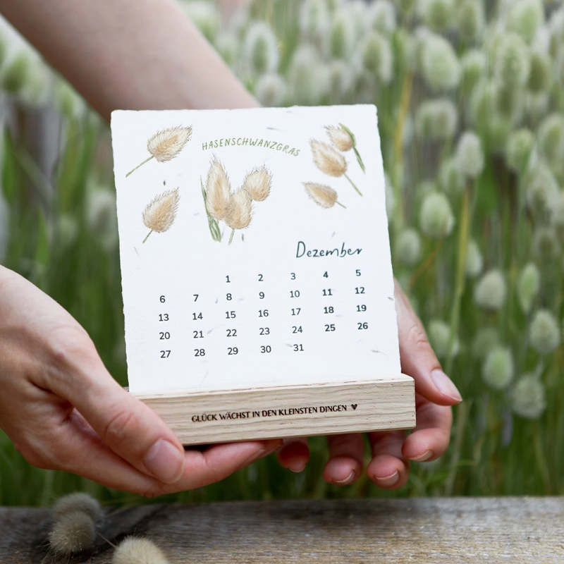 Handgeschöpfter Saatpapier-Kalender mit farbigen Pflanzenillustrationen und eingearbeiteten Samen